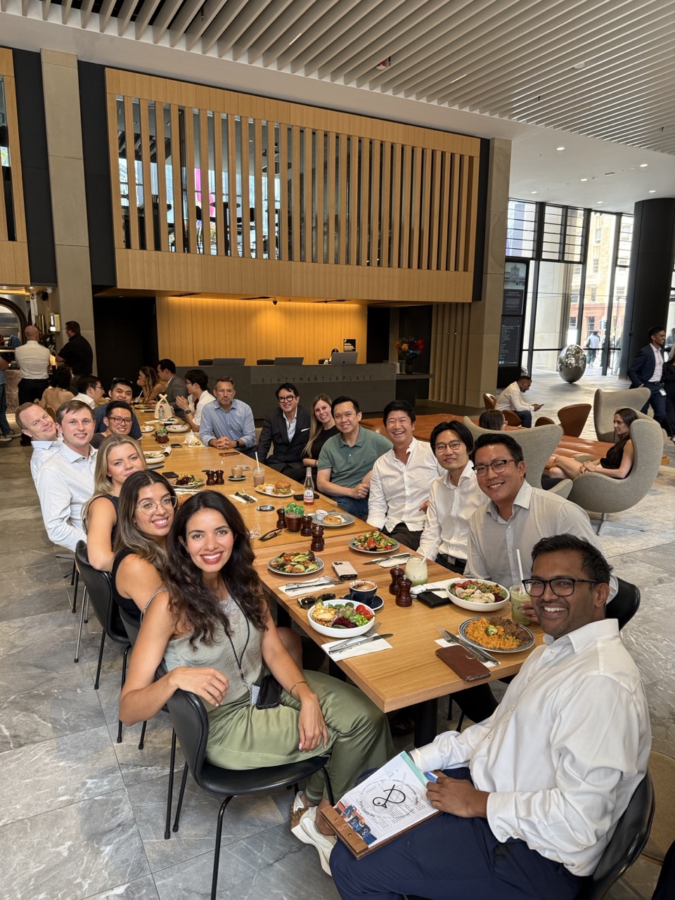 People in work clothes sharing a long-table lunch at a Common Room Business Connect meetup in a city building